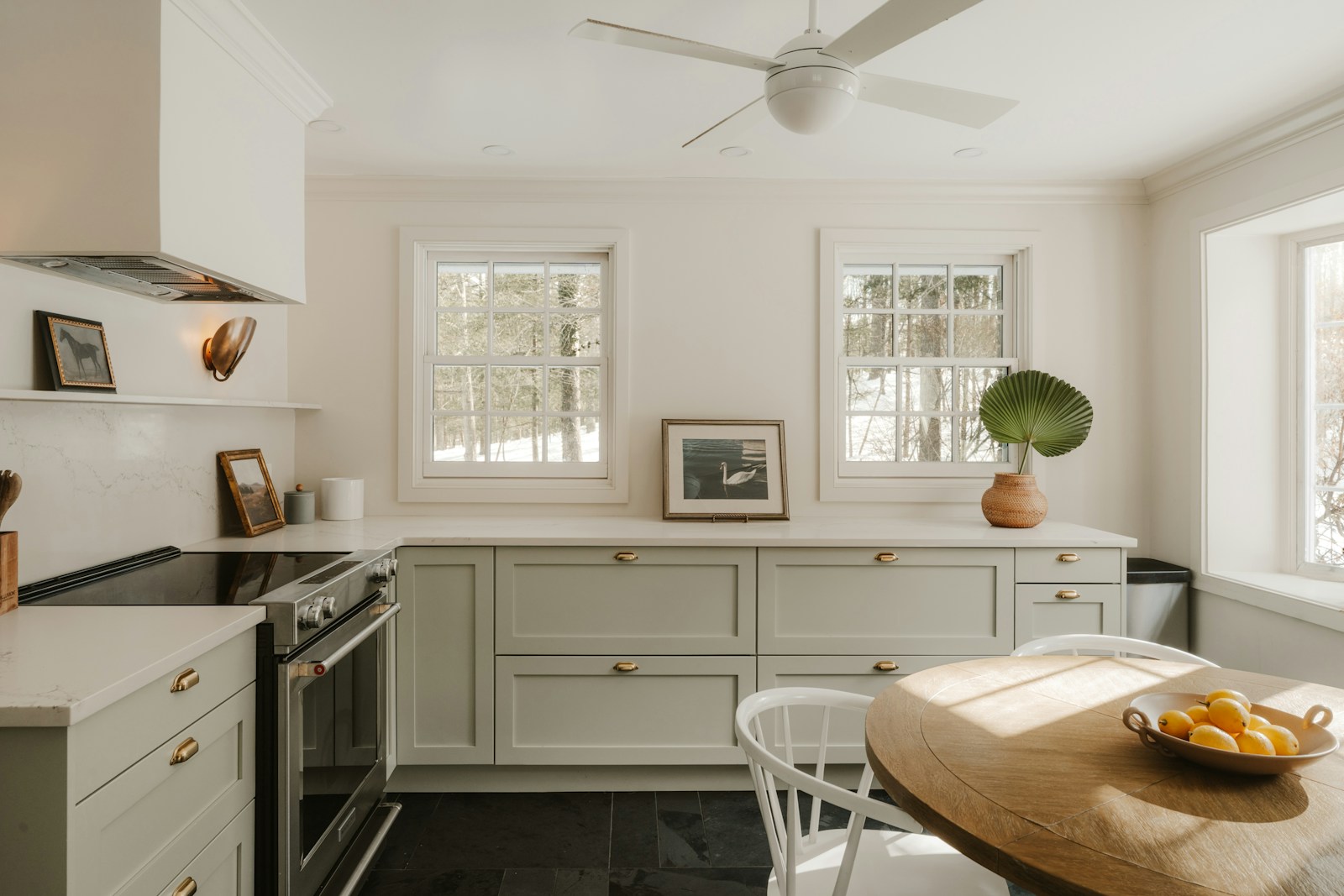 Ranch kitchen with black steel windows over the sink, white cabinets, and brass hardware