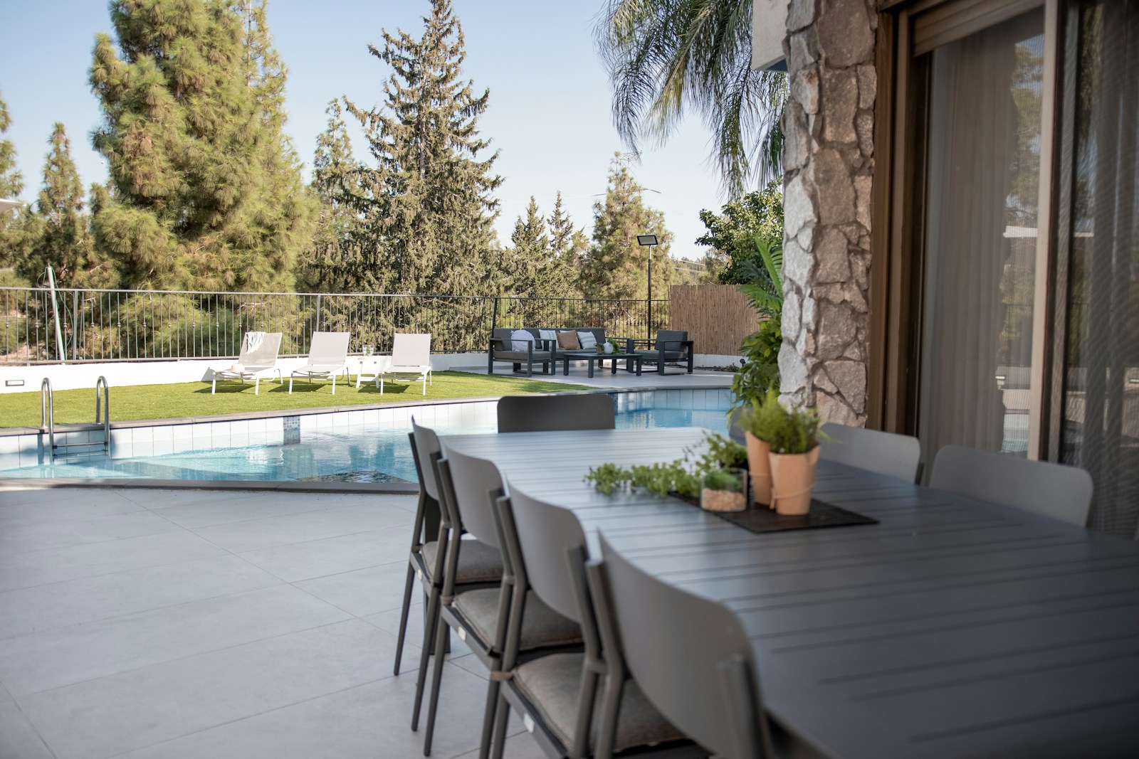 Ranch home with sliding glass doors opening to outdoor dining and patio