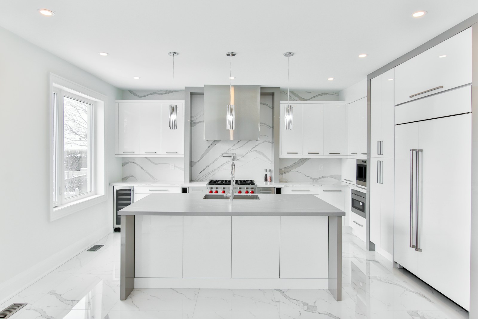 Modern ranch kitchen with sculpted white plaster range hood and marble surround